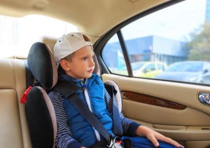 Young boy sitting in a booster car seat