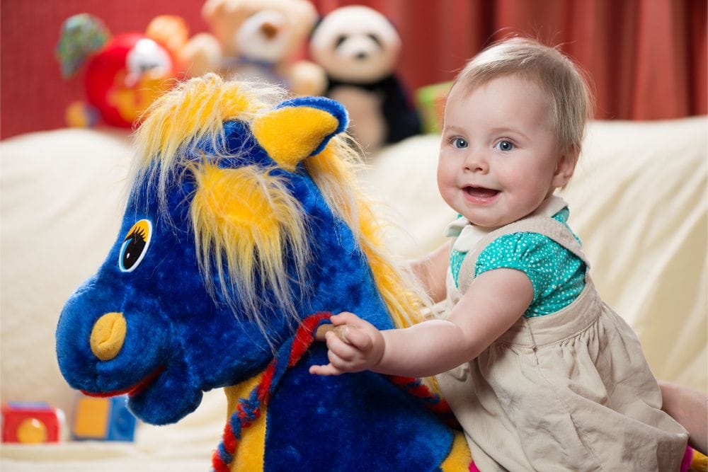 Cute baby girl riding a rocking horse