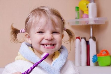 Little girl brushing her teeth in the bathroom