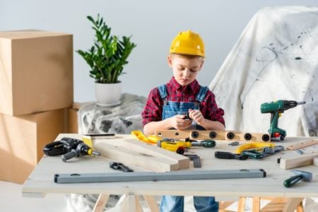 Little boy playing with construction tools