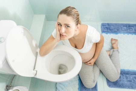 Pregnant woman checking the cloudiness of her urine.