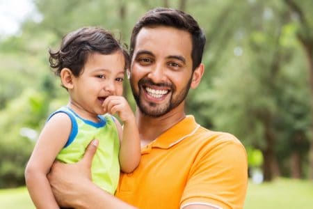 Happy little Indian boy with his father in the park