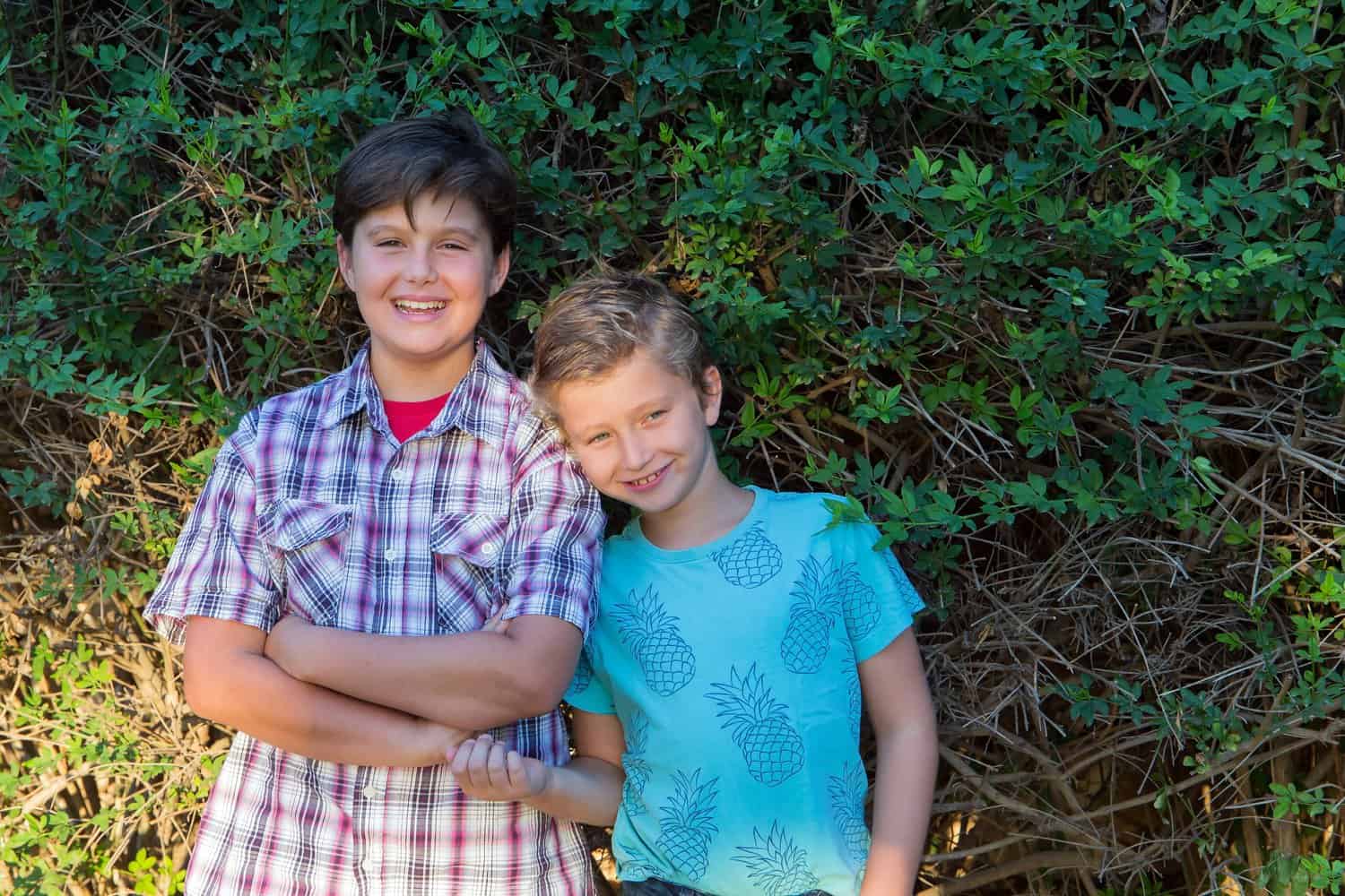 Southern brothers happily resting against nature background