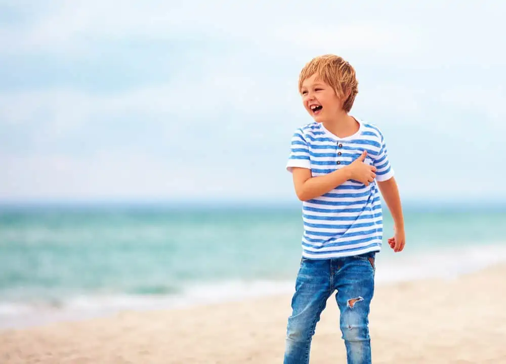 Happy Australian boy playing on the beach