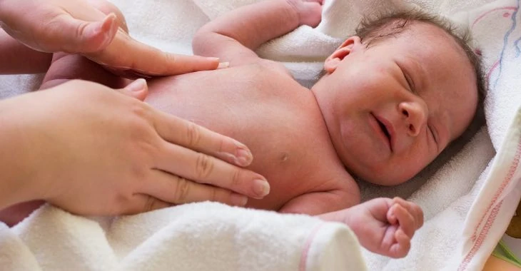 Mother massaging baby with colic