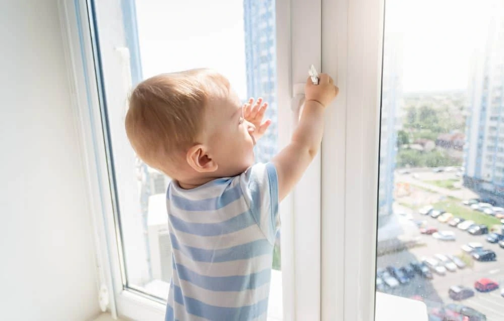 Toddler playing by the window unsupervised