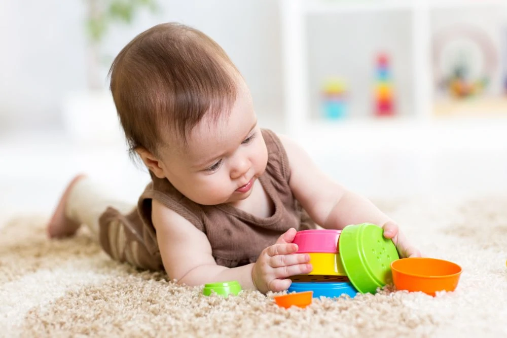 Baby girl playing with stacking toy