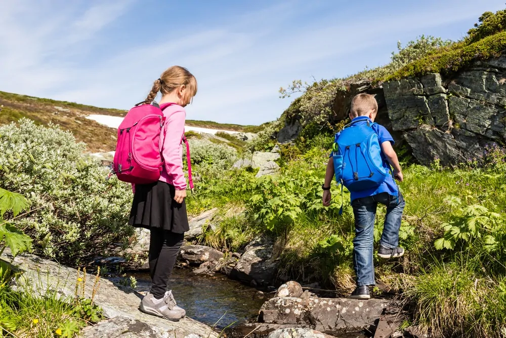 Two kids hiking with hydration backpacks