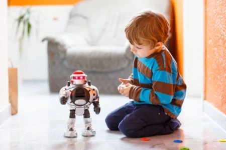 Little boy playing with a robot toy