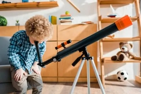 Little boy viewing from a telescope