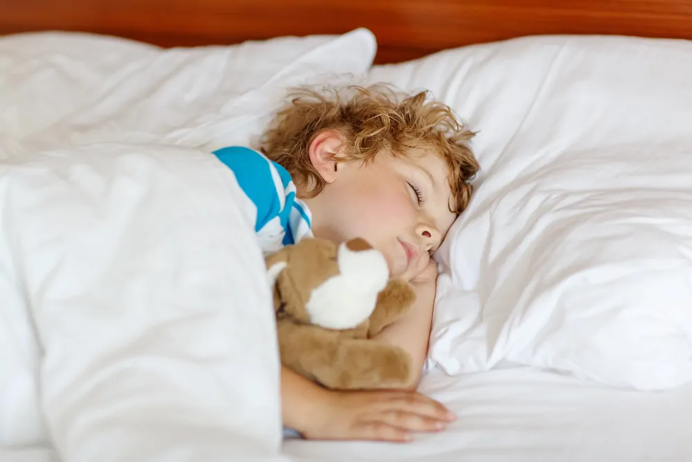 Toddler sleeping in his bed