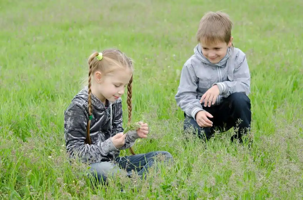 Cute boy sitting and looking at the girl in the park