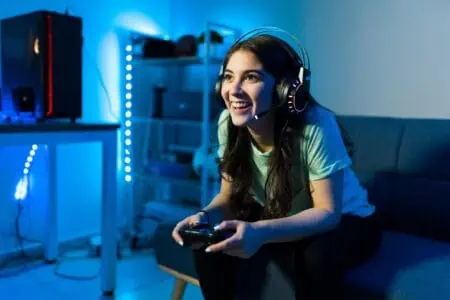 Happy female gamer smiling while playing video game