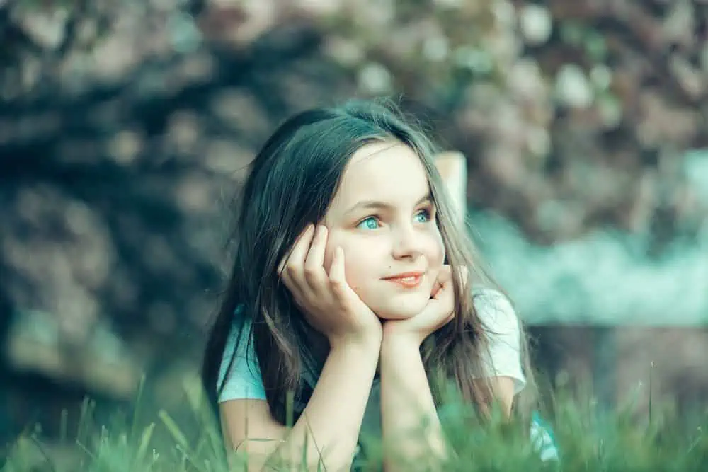 Little girl lying on the grass in the park.