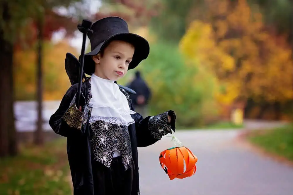 Boy in a magician costume having fun in the park.