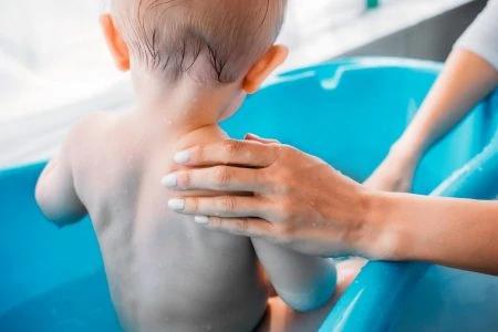 Toddler bathed in a small tub