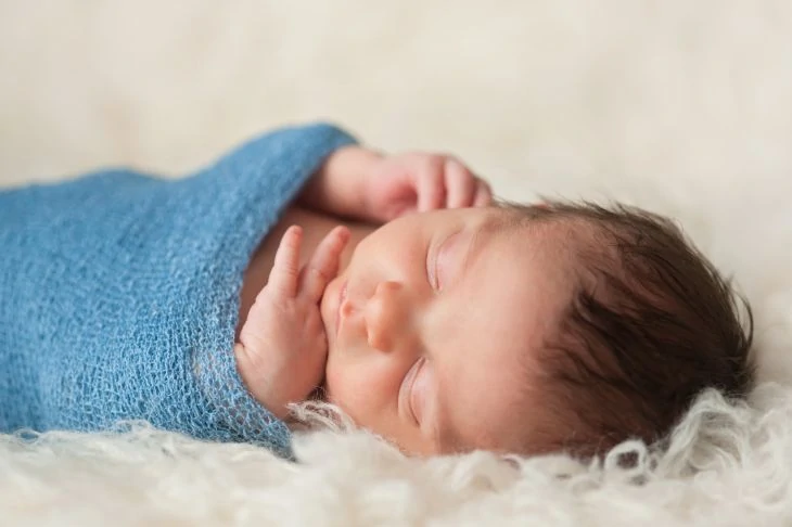 Baby swaddled in a blue blanket