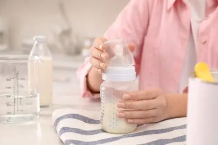 Mother preparing infant formula at the table