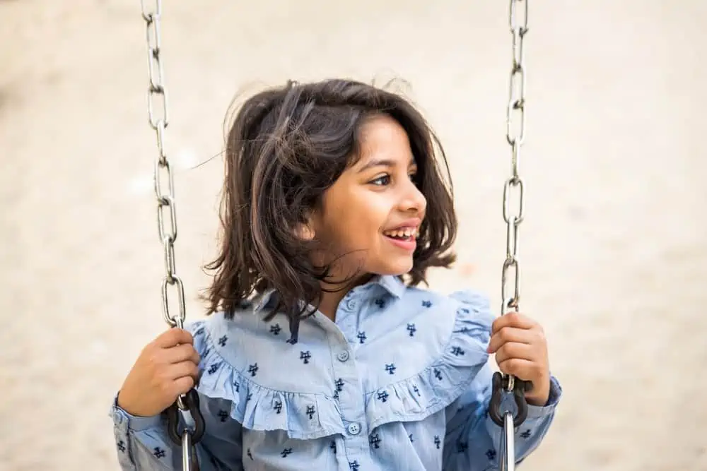 Smiling adorable girl in swing