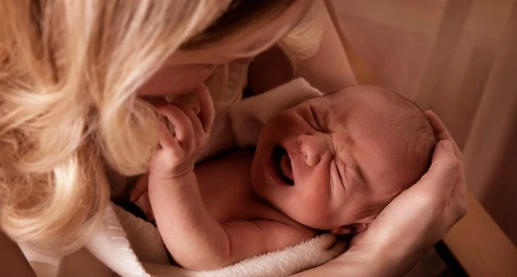 Mother holding crying baby