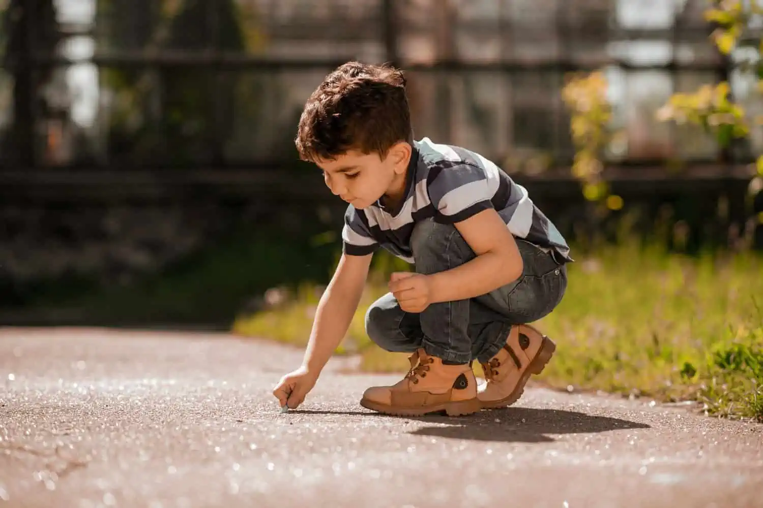 Puerto rican boy drawing something on the ground